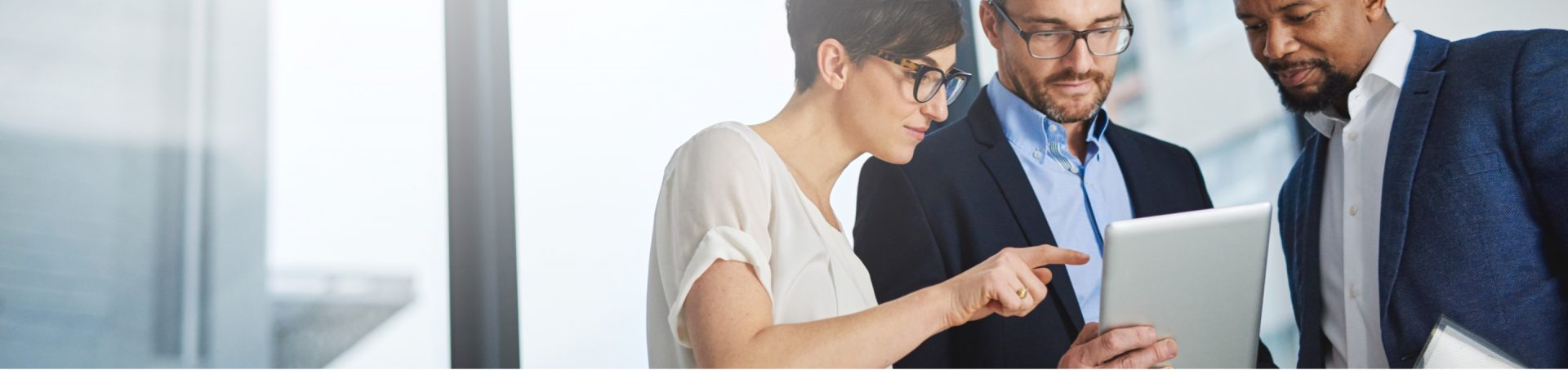 Deux hommes et une femme devant une tablette